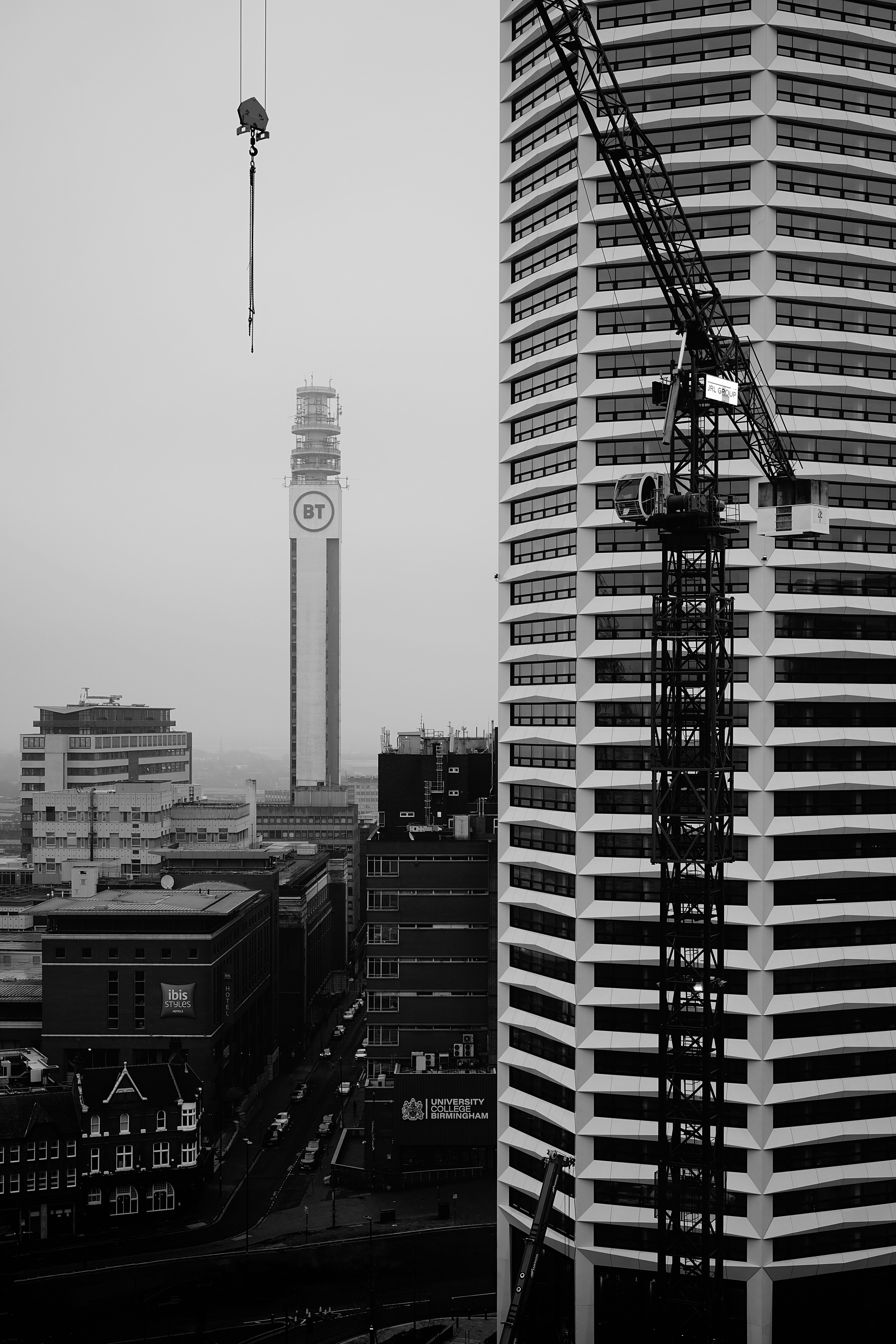 Cityscape with tall buildings and construction crane (Unsplash/@mikehindle/6CvoFRLGU4M)
